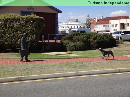 Estátua de um homem, parece ser um viajante, e um cachorro.