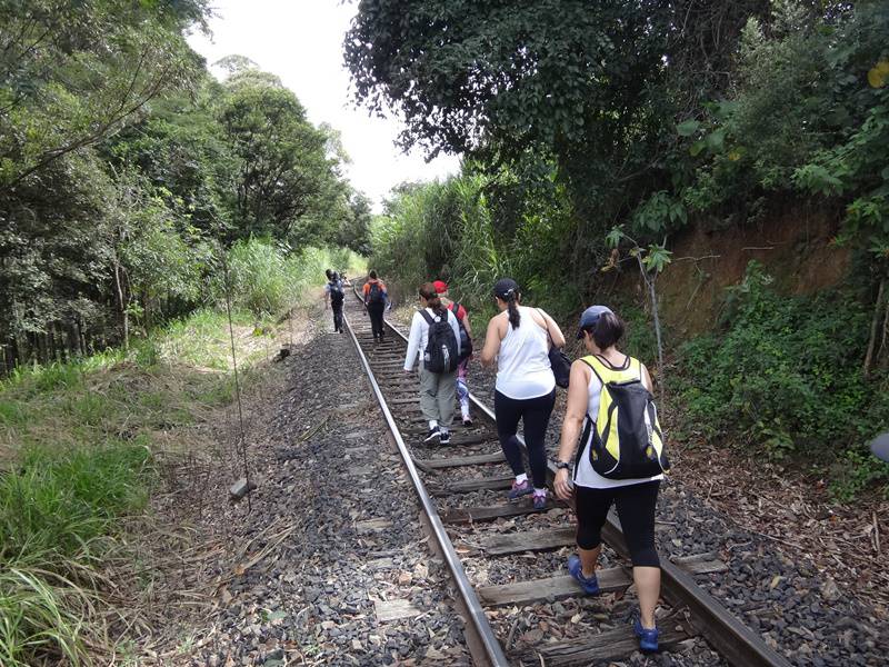 Galera caminhando sobre os trilhos.