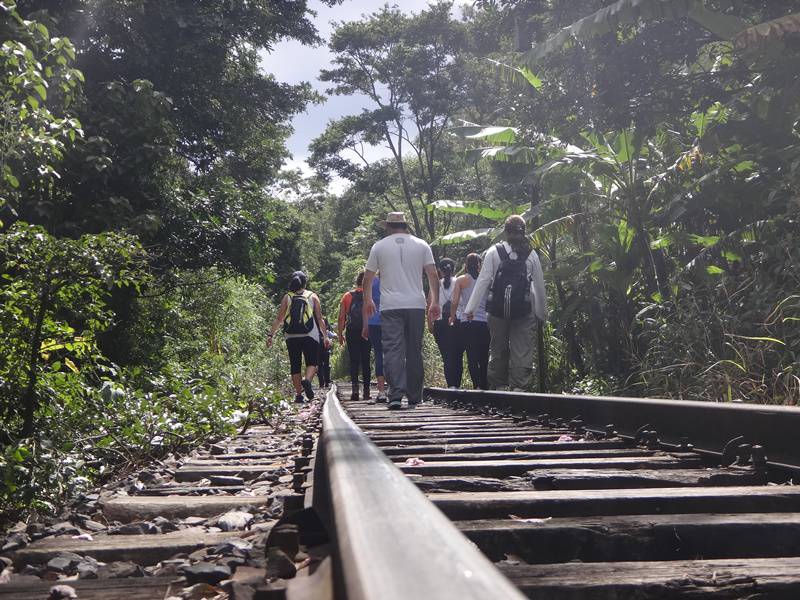 Galera caminhando sobre os trilhos.