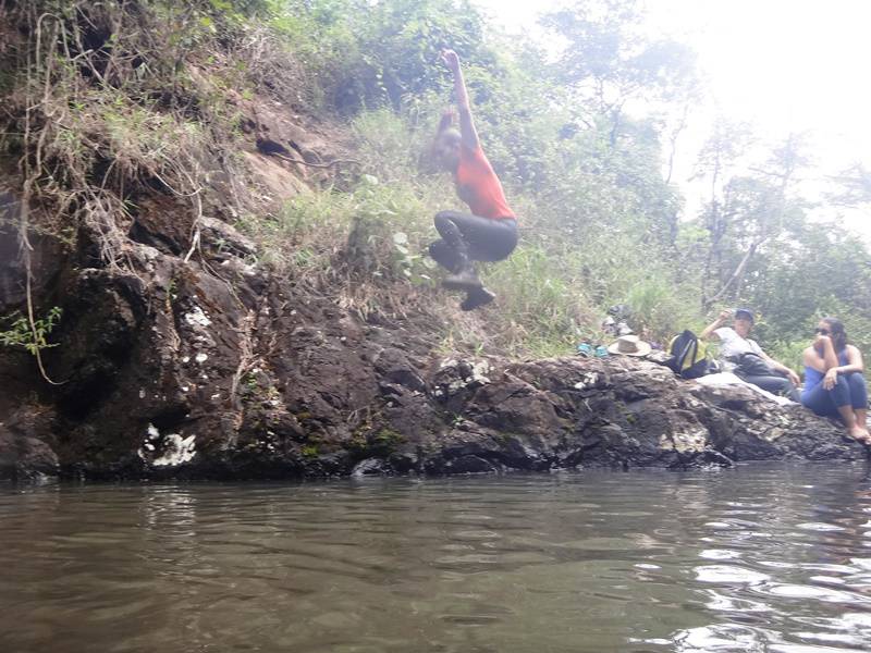 A guia Michele saltando no poço da cachoeira.