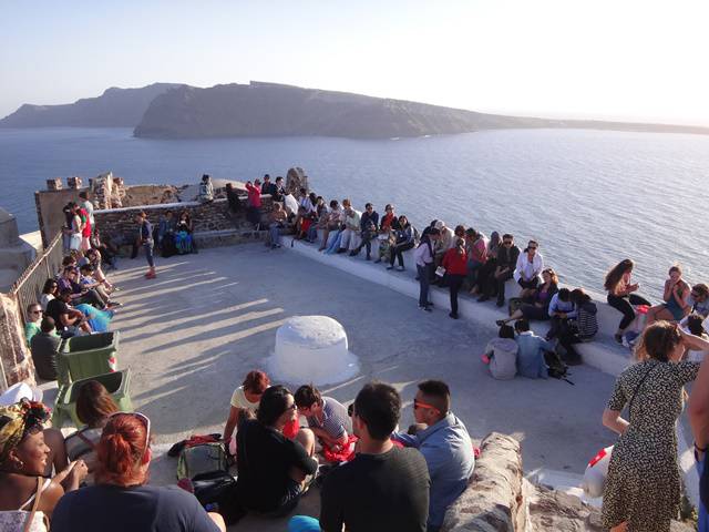 Galera se acomodando para aguardar o pôr do Sol em Oia.