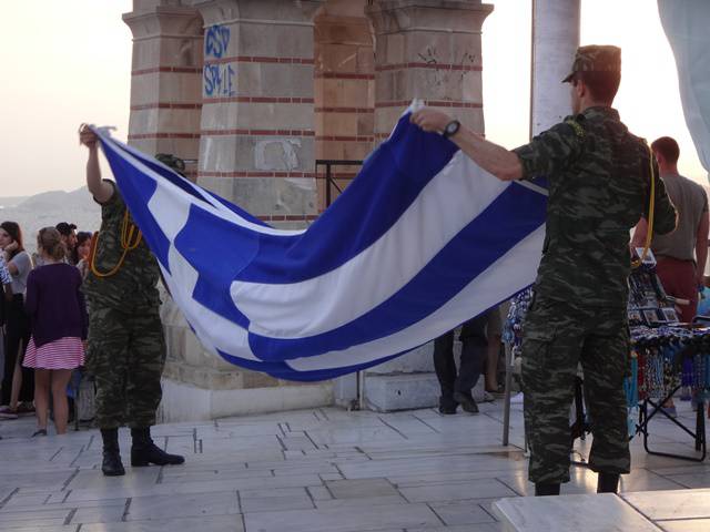 Soldados recolhendo a bandeira grega.