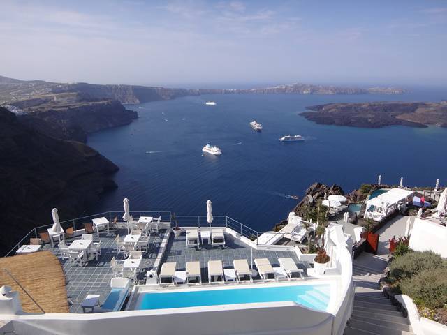 Paisagem e piscina de um hotel com vista para o mar.