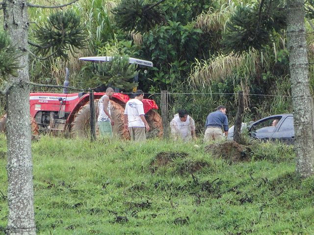 Trator ajudando a desatolar o Peugeot