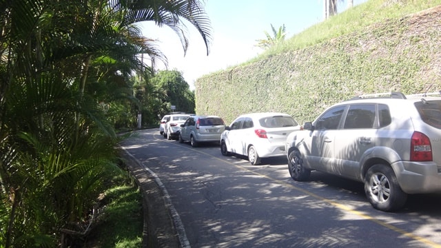 Carros estacionados dentro do condomínio.