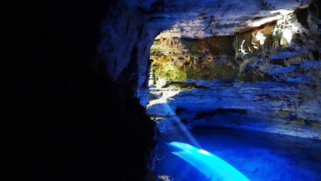 A água reflete a claridade por toda a caverna.