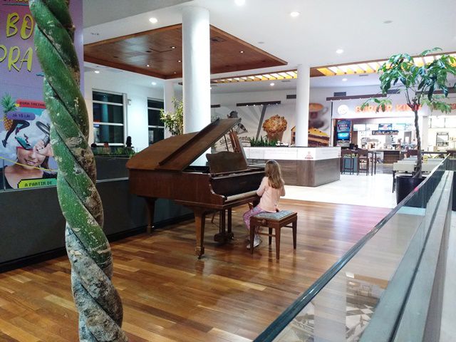 Garotinha tocando piano no Shopping Crystal.