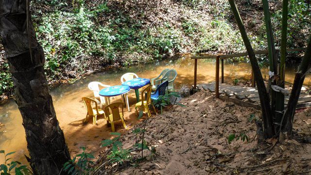 Mesas e cadeiras na margem do rio.