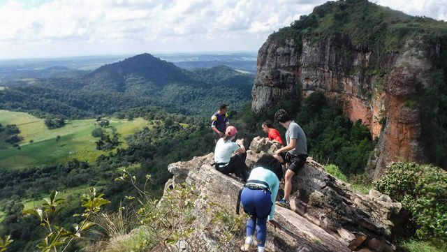 Galera se posicionando para a foto na beirada da pedra