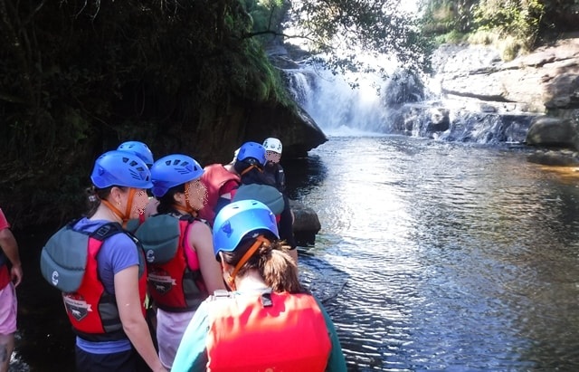 Galera fazendo fila para atravessar o poço da cachoeira